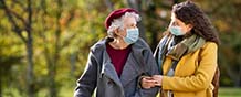 caregiver walking with elderly woman